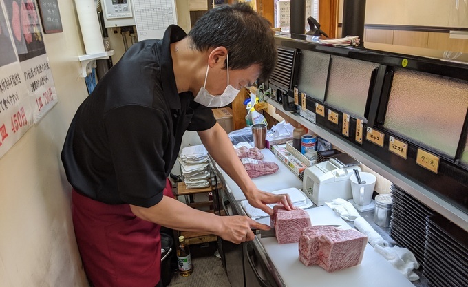 池袋『ひとり焼肉 美そ乃』肉に包丁を入れているところ