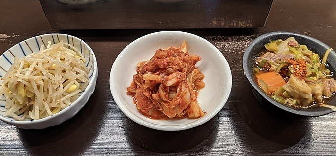 自家製のお通し「豆もやし」「白菜キムチ」「煮込み」